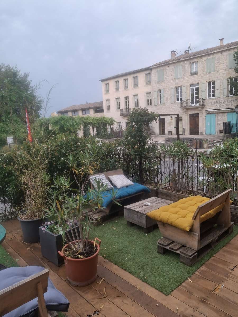 La terrasse : palettes, coussins et jardin devant les façades de pierre de Forcalquier
